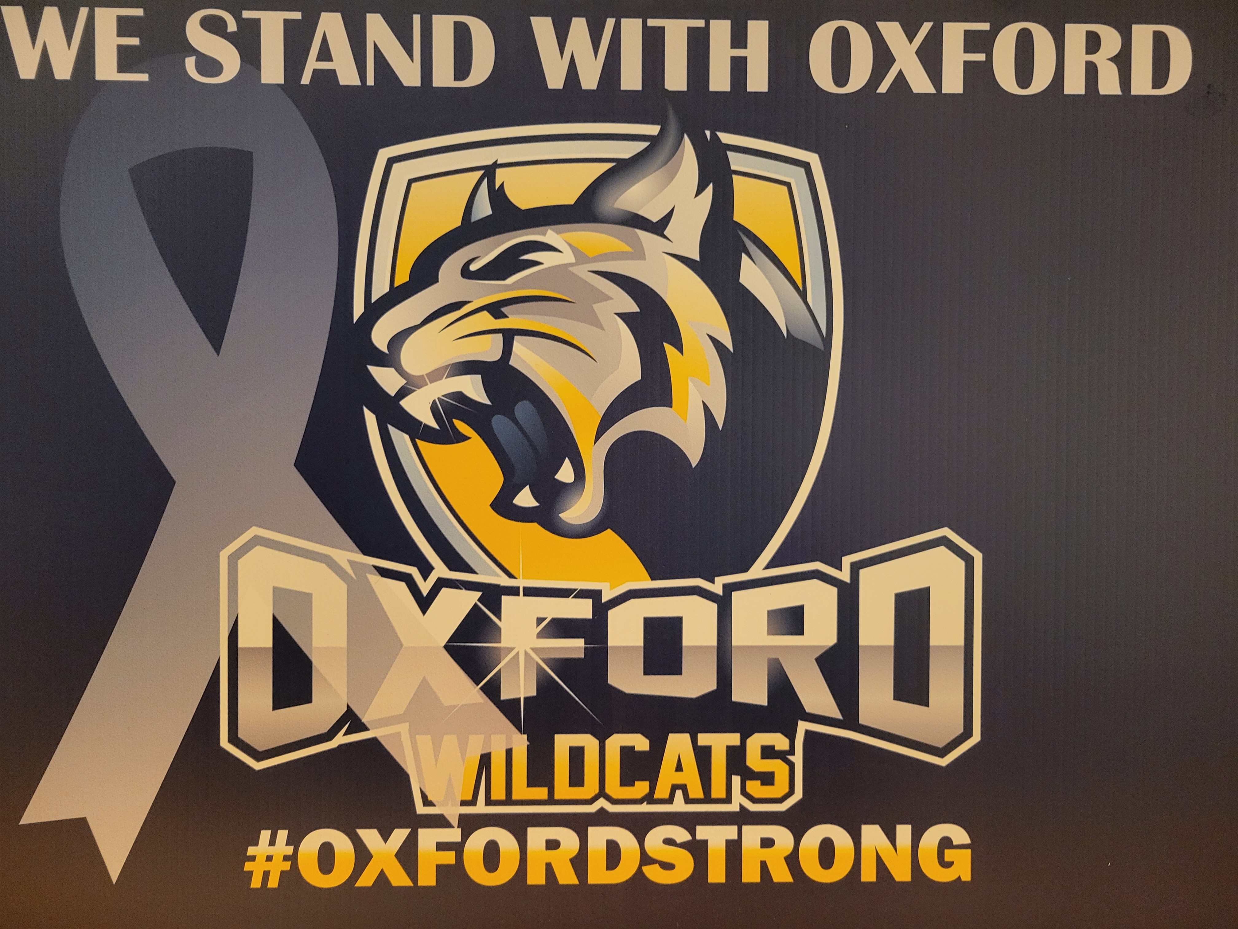 Oxford Strong logo with text saying we stand with Oxford. image of Oxford school logo with wildcat. Overlaid with a ribbon.